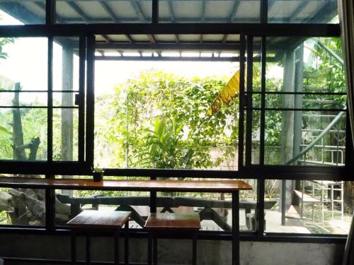 a room with a table and a large window at Bann Rai Klai Weang Homestay in Ban Muang Chum