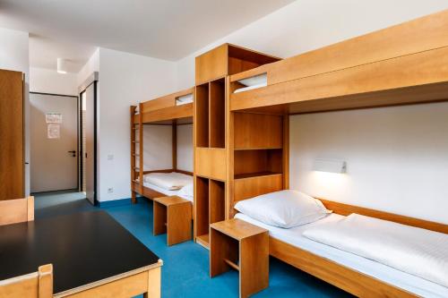 a bedroom with bunk beds and a desk at Jugendherberge Possenhofen in Pöcking
