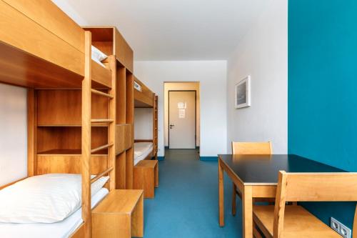 a dorm room with bunk beds and a desk at Jugendherberge Possenhofen in Pöcking