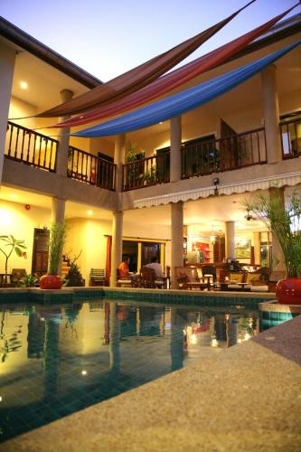 a large house with a swimming pool in front of it at Evergreen boutique Hua Hin in Hua Hin