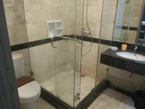 a bathroom with a shower and a toilet and a sink at Tulip Guest House in Bandung