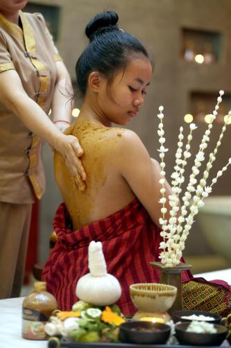 a woman is standing in front of a table with a table at Central Indochine D'angkor Hotel in Siem Reap