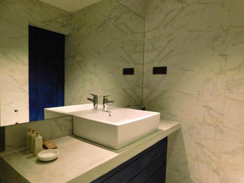 a bathroom with a white sink and a mirror at St Bridget's Country Bungalow in Kandy