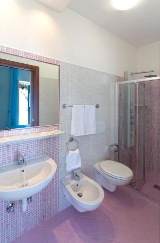 a pink tiled bathroom with a sink and a toilet at Hotel Villa D'Orta in Ischia