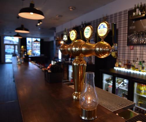 a bar with a gold machine on the counter at Hotell Årjäng in Årjäng