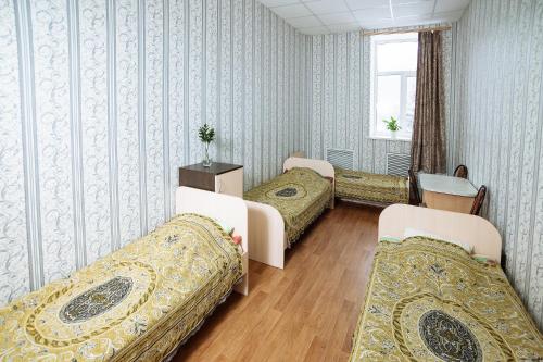 ヨシュカル・オラにあるHostel Comfortの窓のある病室で、ベッド3台が備わります。