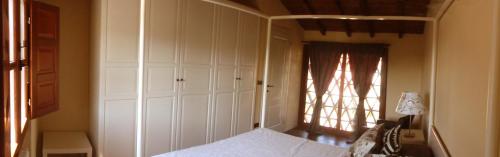 a bedroom with a white bed and a window at Rose Cottage Tuscany in Fosdinovo