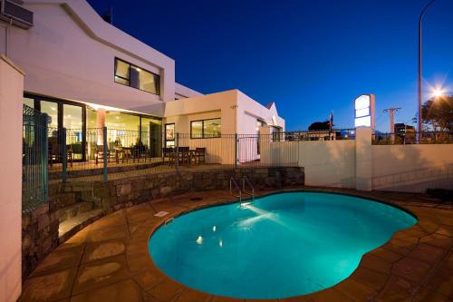 a swimming pool in the backyard of a house at Best Western Ellerslie International Hotel in Auckland