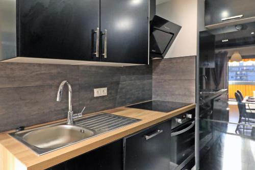 - une cuisine avec des placards noirs et un évier dans l'établissement SOPHIES HOMES APARTEMENT BEACH and PROMENADE DES ANGLAIS, à Nice
