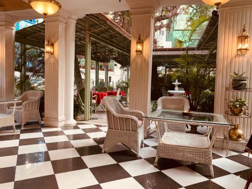 a lobby with wicker chairs and a table and a checkered floor at The Elgin Fairlawn, Kolkata in Kolkata