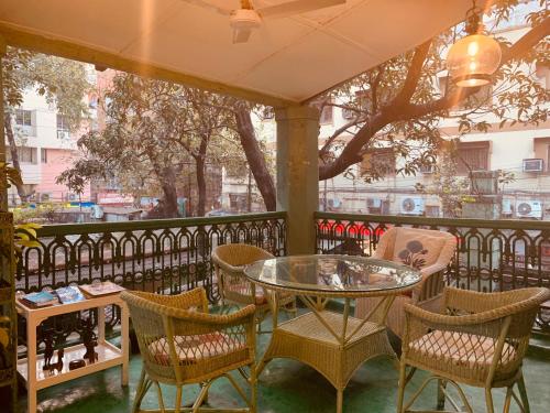 a patio with a glass table and chairs at The Elgin Fairlawn, Kolkata in Kolkata