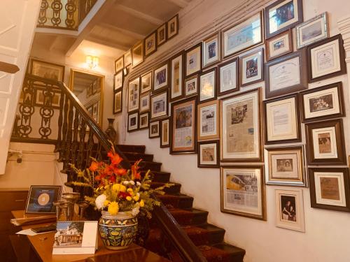 a staircase with a bunch of pictures on the wall at The Elgin Fairlawn, Kolkata in Kolkata
