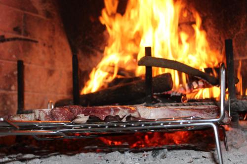 a grill with two pieces of meat in front of a fire at Società Agricola F.lli Angelucci in Cannara