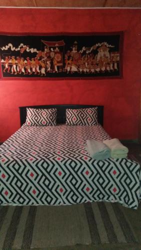 a bedroom with a bed with a red wall at Mini's Residence in Colombo