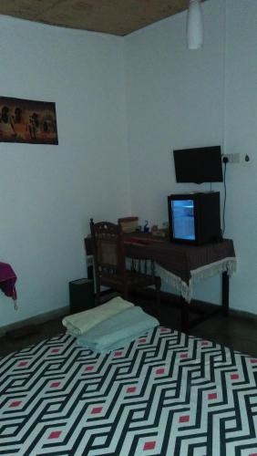 a room with a bed and a desk with a computer at Mini's Residence in Colombo
