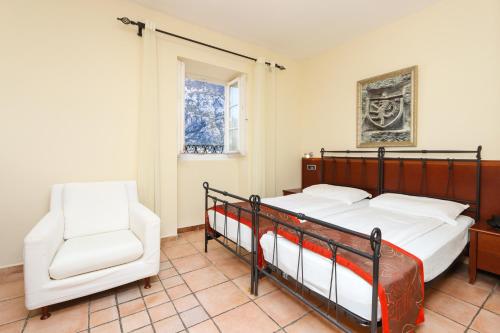 1 Schlafzimmer mit 2 Betten und einem Stuhl in der Unterkunft Hotel Splendido in Kotor
