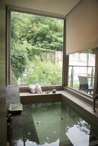 a bathroom with a large window and a pool at Cedarwood Villa in Tai'an
