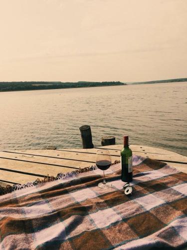 a glass of wine sitting on a table next to the water at GOL&Wood in Stepashki