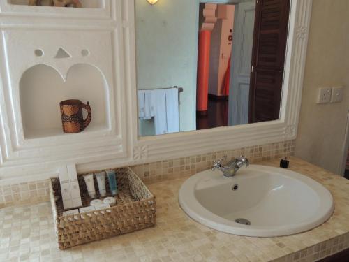 a bathroom with a sink and a mirror and towels at Hotel Villa Malindi in Malindi