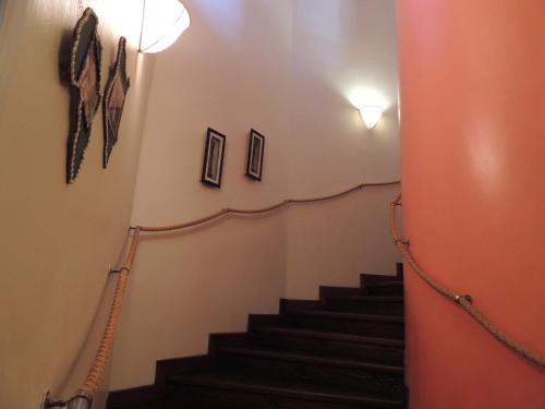 a hallway with stairs with a light and pictures on the wall at Hotel Villa Malindi in Malindi