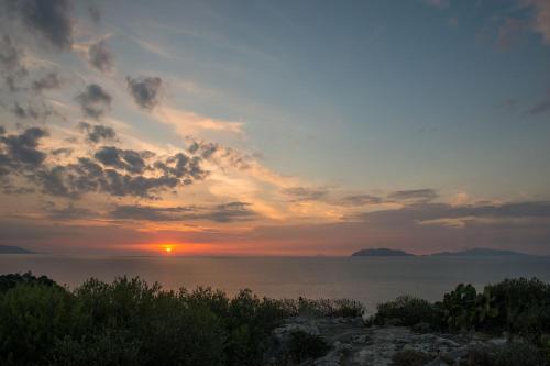 a sunset over the ocean with the sun in the sky at Manzoni Elements in Milazzo
