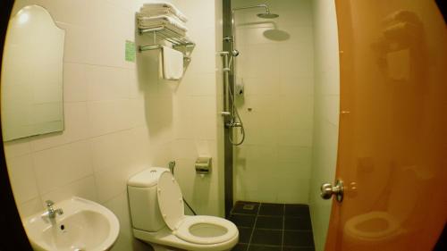 a small bathroom with a toilet and a sink at Super 8 Hotel @ Georgetown in George Town