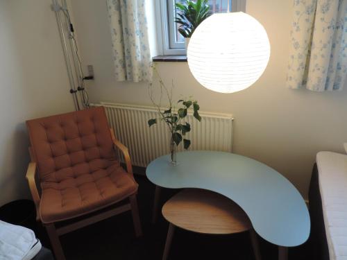 a table and a chair in a room at Ibsens Gaard in Ebeltoft