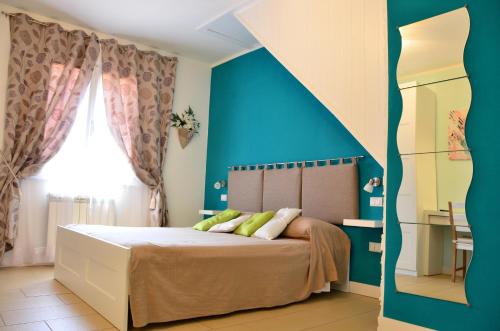 a bedroom with a bed with a blue wall at La Villa di Montagnana in Montagnana