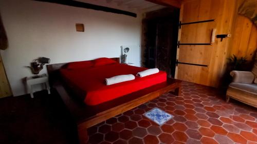 a bedroom with a red bed in a room at La bergerie du chateau de Fitou in Fitou