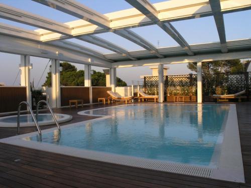 a large swimming pool with a retractable roof at Aparthotel England in Riccione