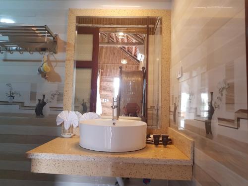 a bathroom with a white sink and a mirror at Tam Coc Wonderland Bungalow in Ninh Binh