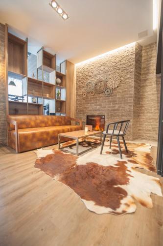 a living room with a couch and a table and a fireplace at Ostend Hotel in Ostend