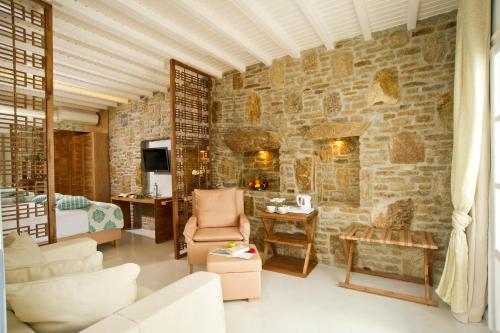 a living room with a stone wall at Petinos Beach Hotel in Platis Yialos Mykonos