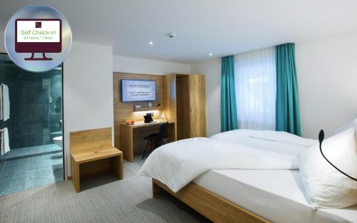 a bedroom with a bed and a desk and a television at Hotel Vaduzerhof by b-smart in Vaduz