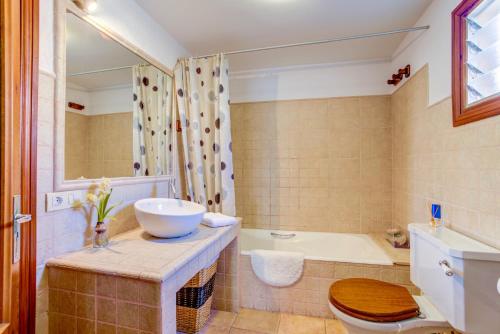 a bathroom with a sink and a toilet and a tub at Casa Coll by Sealand Villas in Pollença