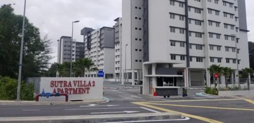 an empty street in a city with tall buildings at Sutra Damai in Kampung Saberang Balok