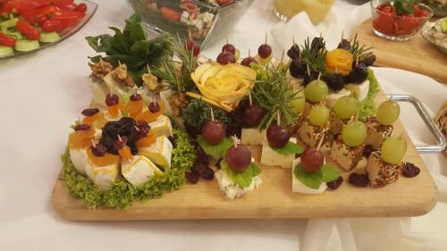 a wooden cutting board filled with different types of food at Hotel Chabrowy Dworek in Teresin