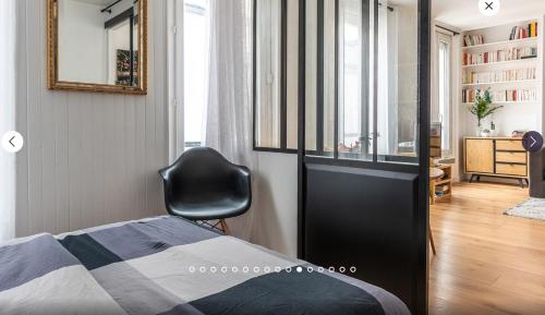 ein Schlafzimmer mit einem Bett und einem Stuhl in einem Zimmer in der Unterkunft Appartement type loft in Paris