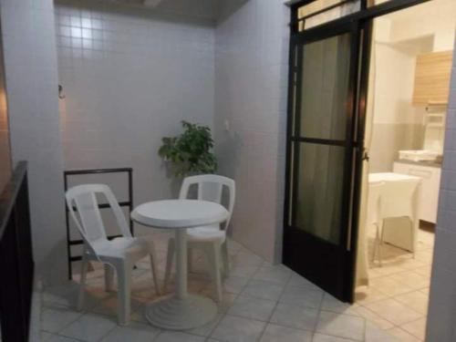 a kitchen with a table and two white chairs at Apto Rua da Praia in Florianópolis