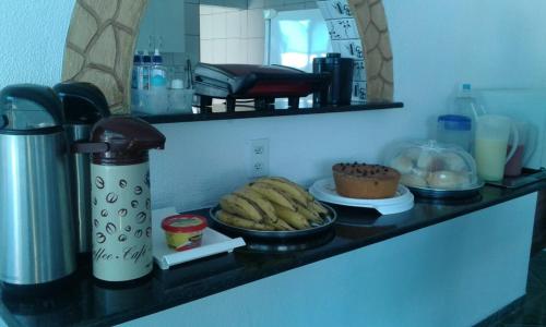 a kitchen counter with some food on a shelf at POUSADA OLÍMPIA in Maceió