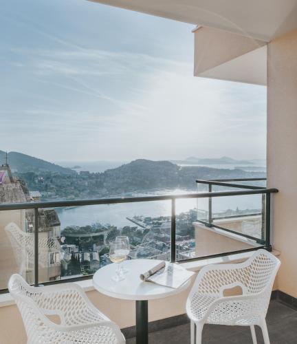 a white table and chairs on a balcony with a view at Hotel Adria in Dubrovnik