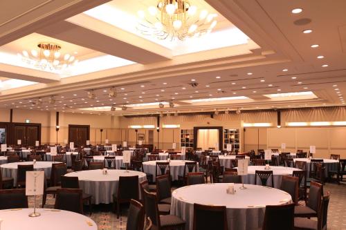 a large banquet hall with white tables and chairs at Business Hotel Noda in Noda