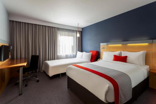 a hotel room with two beds and a desk at Holiday Inn Express Birmingham Redditch by IHG in Redditch