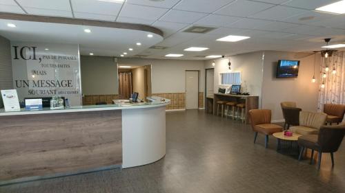 a waiting area of a hospital with a counter and chairs at Kyriad Prestige - Bordeaux Aeroport in Mérignac