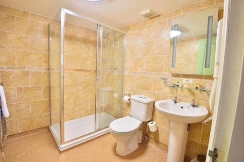 a bathroom with a toilet and a shower and a sink at The Angel Hotel in Coleford
