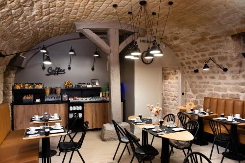 un restaurant avec des tables et des chaises dans une salle dans l'établissement Hôtel du Jardin des Plantes, à Paris