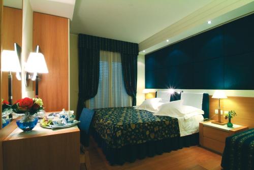 a hotel room with a bed with a large window at Aparthotel England in Riccione