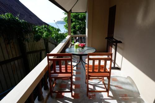 a table and two chairs on a balcony at Kata Beachwalk Hotel and Bungalows in Kata Beach