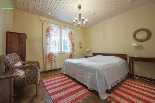 sypialnia z łóżkiem, krzesłem i oknem w obiekcie Huvilaranta Villas w mieście Isojärvi