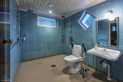 uma casa de banho azul com um WC e um lavatório em Huvilaranta Villas em Isojärvi